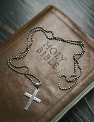 Silver Cross Pendant Necklace on Brown Holy Bible