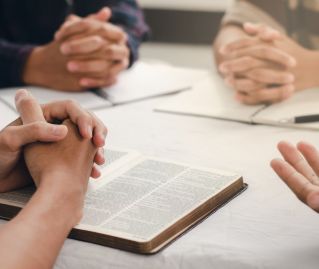 Close-up of a hand holding the Holy Scriptures, focusing on religious and spiritual themes.